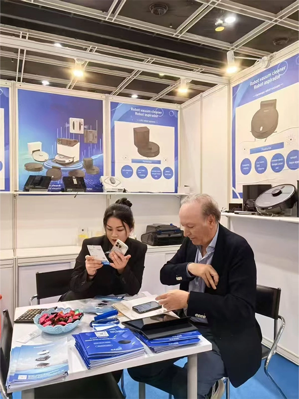 Kingbot sales representative discussing robot vacuum products with an overseas buyer at a trade show